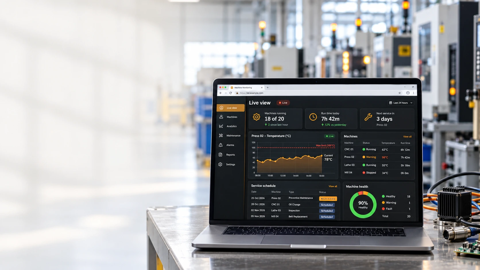 Laptop on a steel workbench in a factory, showing the live machine monitoring dashboard